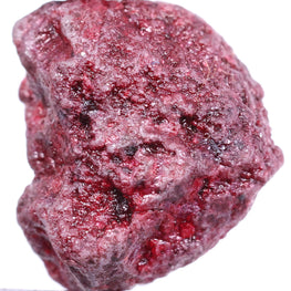 Raw red diamond held by tweezers on a white background