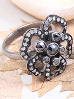 Silver ring with floral design on a white background