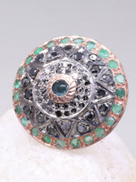 Decorative ring with gemstones on a white shell against a gray background
