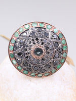 Decorative brooch with gemstones on a white stone