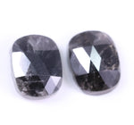 Two oval-shaped black stones on a white background