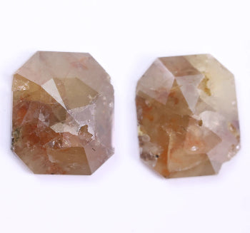 Two octagonal cut gemstones on a white background