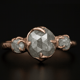 Ring with a large central rose cut diamond and rough and smaller ones on a dark background