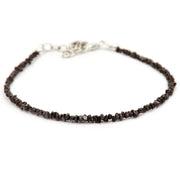 Close-up of a rough diamond bracelet with natural raw diamonds on a minimalist setting.