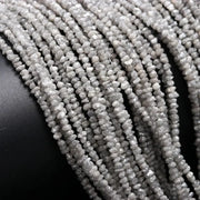 Collection of raw natural diamonds including a raw diamond, raw blue diamonds, grey diamond beads, raw diamond strand