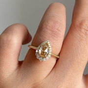 pear cut yellow diamond ring with round diamond halo 