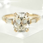 cushion cut diamond ring with baguette side stones in yellow gold