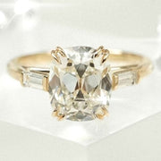 cushion cut diamond ring with baguette side stones in yellow gold
