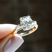 cushion cut diamond ring with baguette side stones in yellow gold