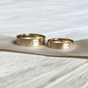 Rose gold couple rings with engraved initials, a romantic personalized gift idea.