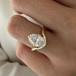 2 carat oval diamond three-stone ring set in white gold on a woman’s hand