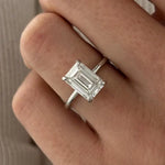 3 carat oval diamond three-stone ring set in polished white gold on a woman’s hand