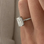 3 carat oval diamond three-stone ring set in polished white gold on a woman’s hand