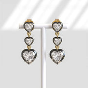 Heart-shaped diamond earrings on a white background