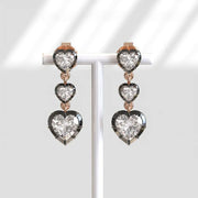Heart-shaped diamond earrings on a white background