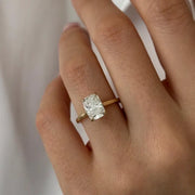 Oval 2 carat diamond engagement ring in white gold displayed on a hand with soft neutral manicure