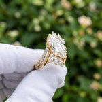 Marquise cut diamond ring with floral side stones in yellow gold
