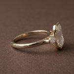 3 stone emerald engagement ring with elegant diamond setting