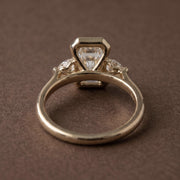 3 stone emerald engagement ring with elegant diamond setting