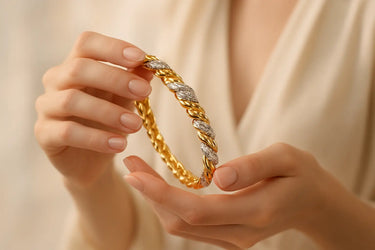 Gold and silver braided bracelet held by a person against a neutral background Woman wearing a gold bracelet on a beige background.bracelet made weith natural diamond and labgrown diamond. gift for her.made by jayamar gems. 